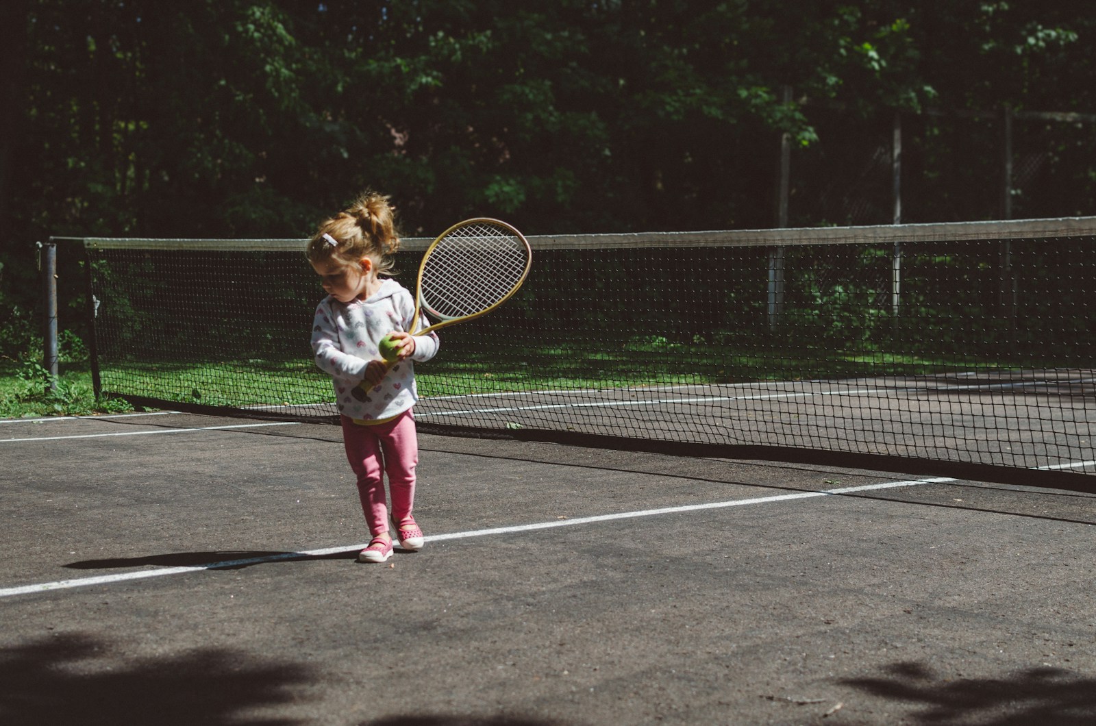 Young child playing tennis on court
