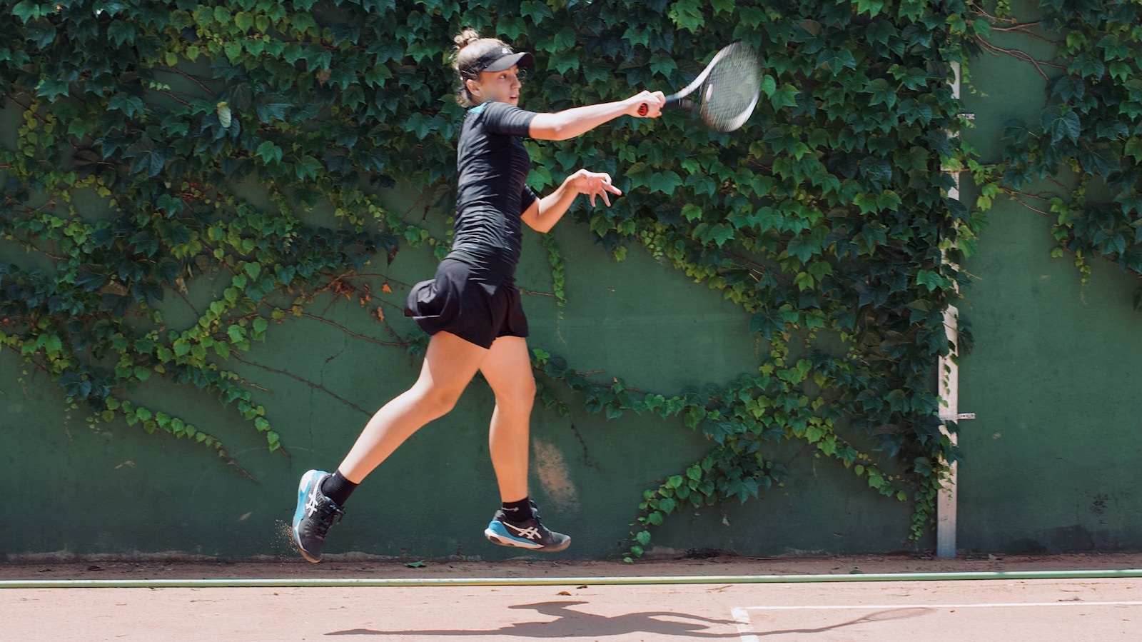 Athlete jumping to hit a tennis forehand